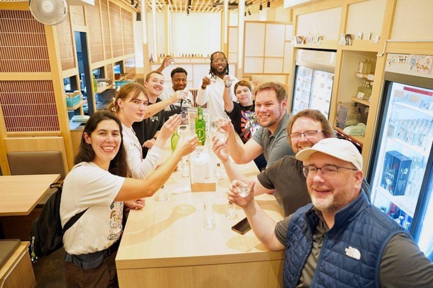 A group of people toasting with drinks at a bar. 5