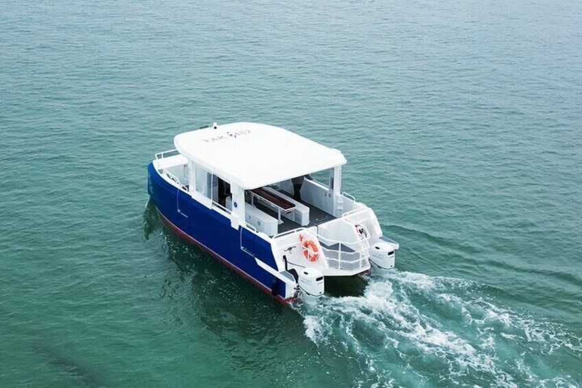 A blue and white boat with a white canopy, moving through calm water. 5
