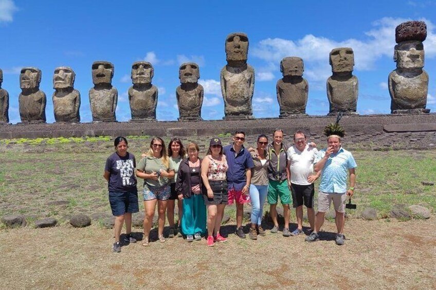 A group of people standing in front of large stone statues. 3