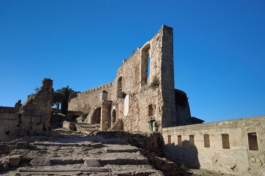 Ancient ruins with stone steps leading up to a tall, narrow tower. 5