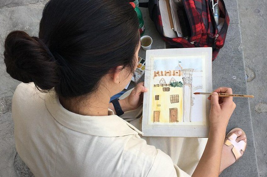 A person painting a building on a canvas. 5
