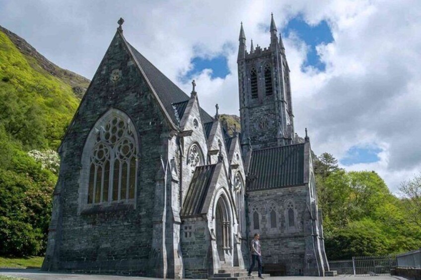 Een historische stenen kerk met spitsboogvensters en een hoge klokkentoren. 3