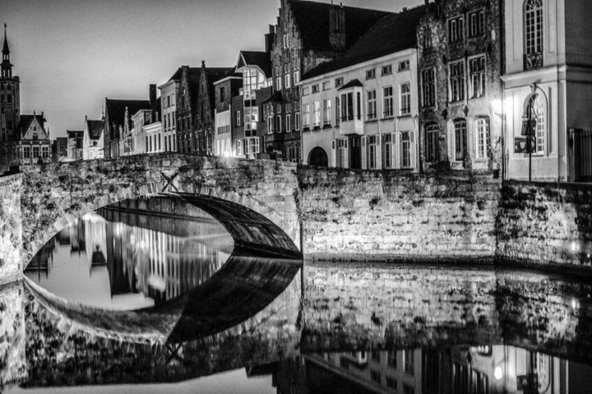A historic canal with a bridge, buildings, and a church. 4