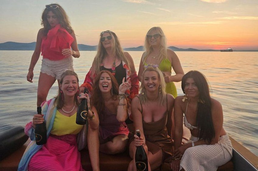 A group of people on a boat with a sunset in the background. 4