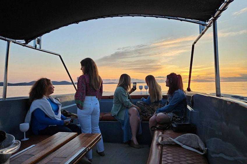A group of people on a boat during sunset. 3