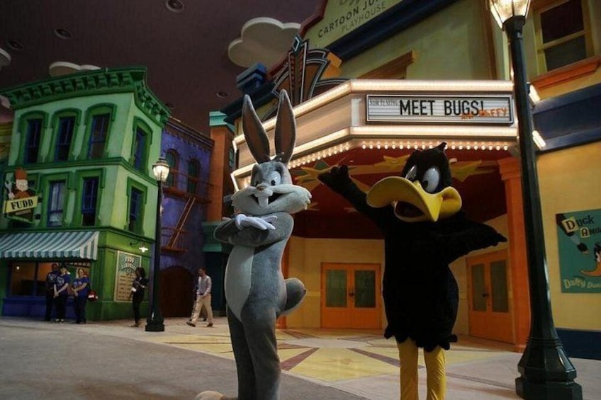 Two animated characters standing in front of a theater with a sign that reads 'MEET BUGS!' 3