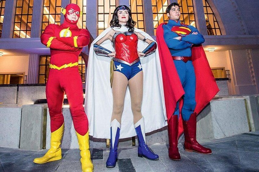 Three costumed characters standing in front of a building with large windows. 5
