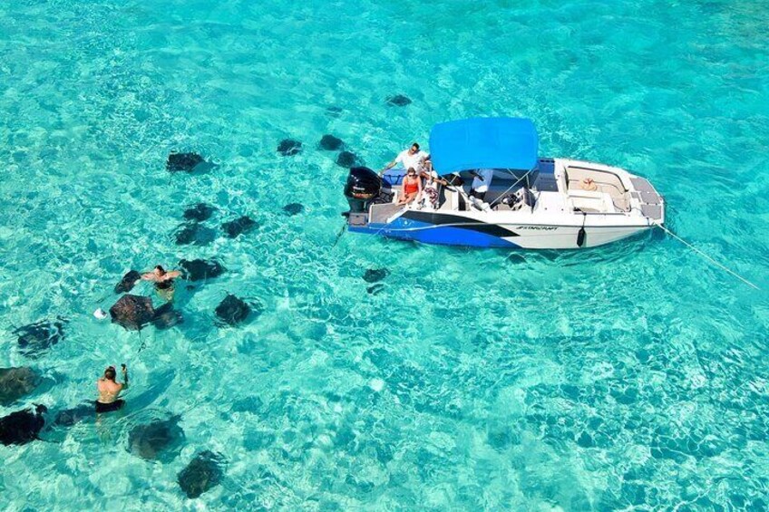Un bote con gente haciendo snorkel en aguas turquesas y cristalinas. 2