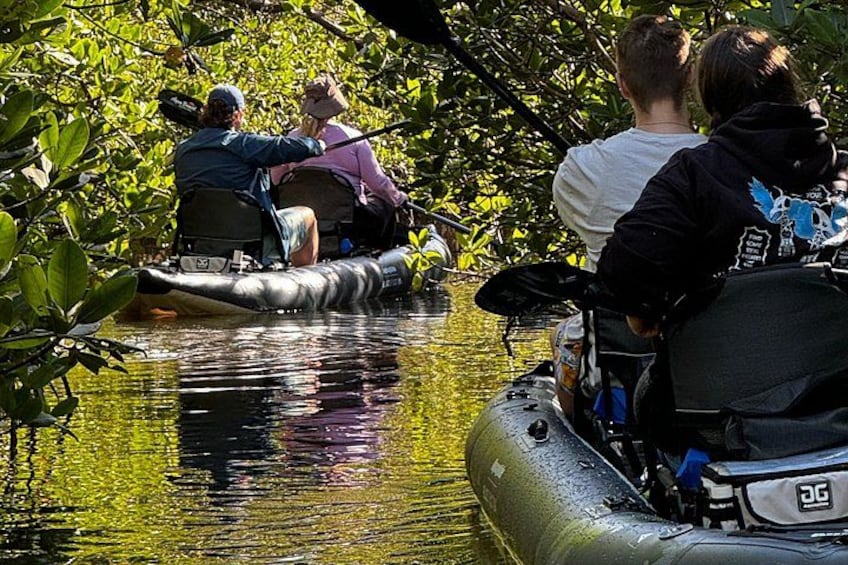 Menschen auf einem Floß in einem Fluss, umgeben von dichtem Grün. 1