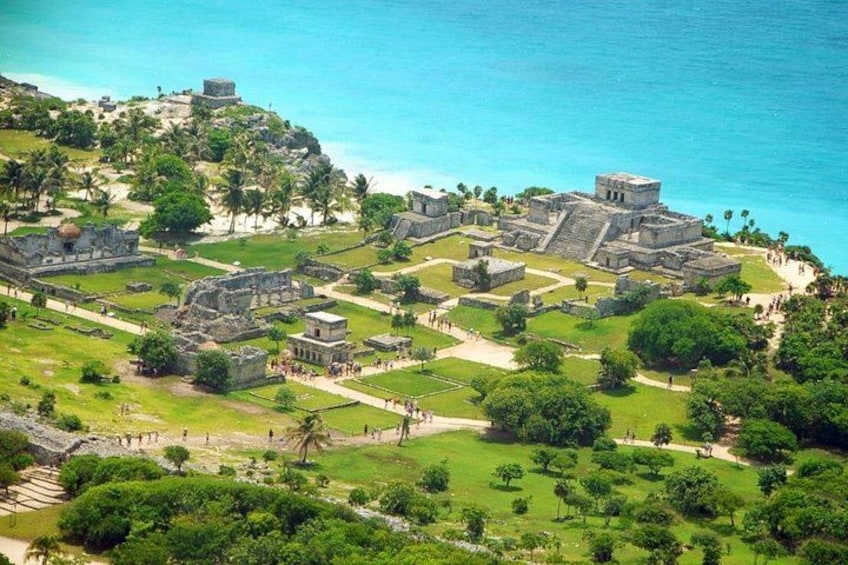 An aerial view of a historical site with ruins, pathways, and palm trees. 5