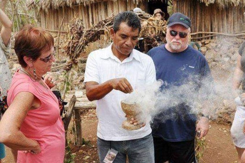 A man in a white shirt and jeans, a woman in a pink top, and another man in a blue shirt standing outdoors. 2