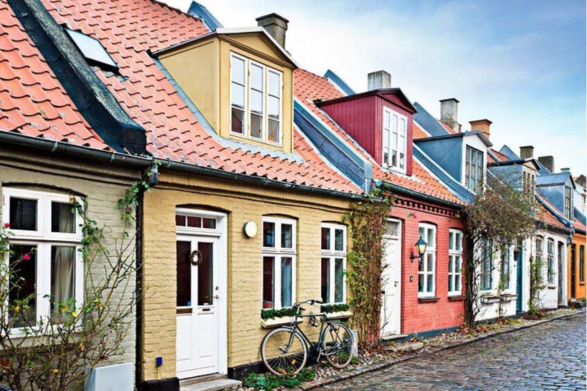 A row of colorful houses with red and yellow roofs, a bicycle, and a cobblestone street. 2