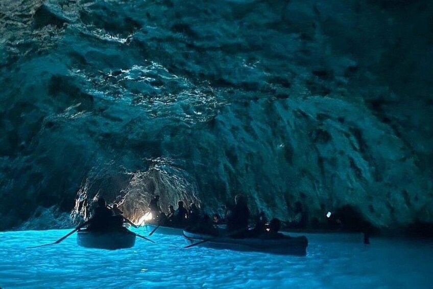 Una cueva con agua y personas en botes. 2