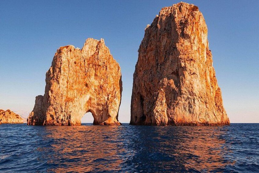 Dos grandes formaciones rocosas con un arco en el centro, rodeadas de agua. 3