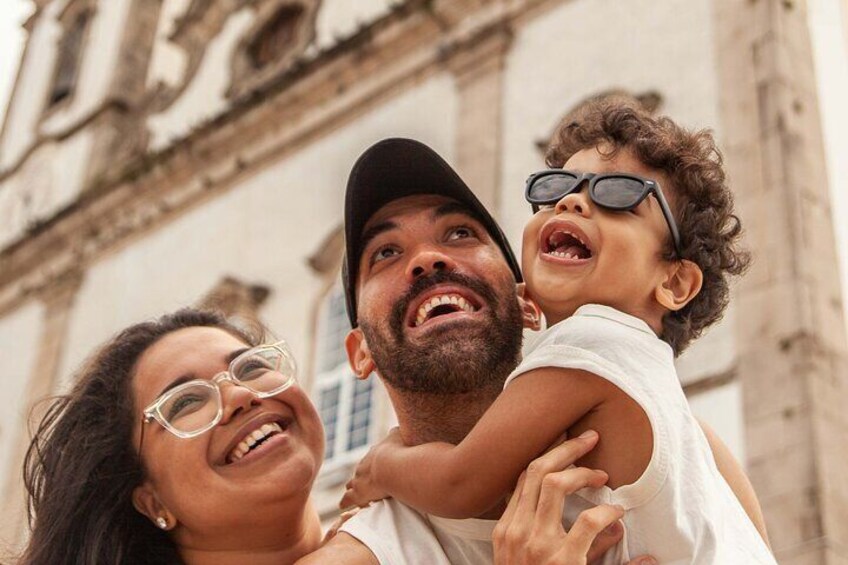 Une personne portant un enfant devant un bâtiment historique à l’architecture riche et ornée. 3