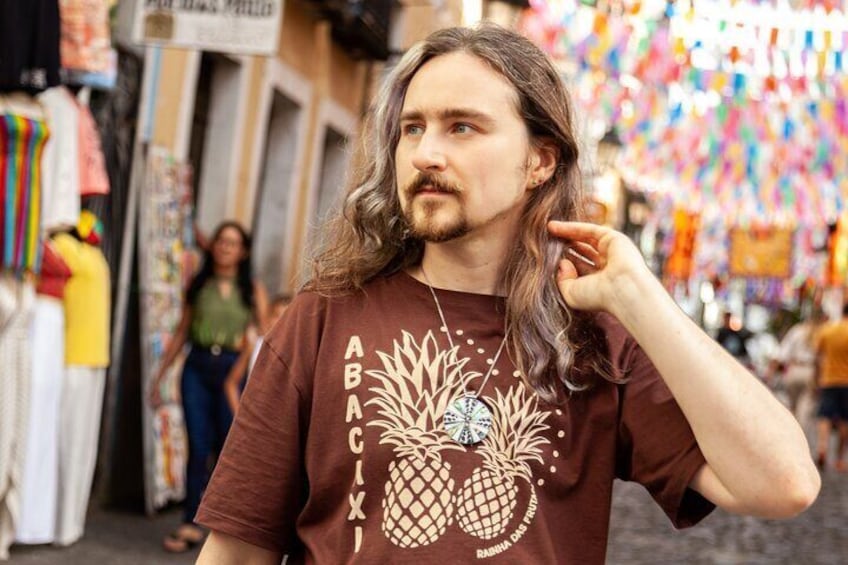 Una persona con camiseta marrón con un diseño de piña y el texto "ABACIXI". 3