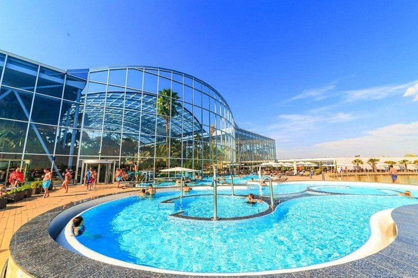 A modern glass building with a pool area. 2