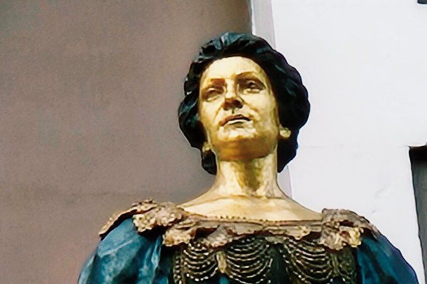 Una statua con un copricapo scuro e un abito blu con bordo dorato. 3