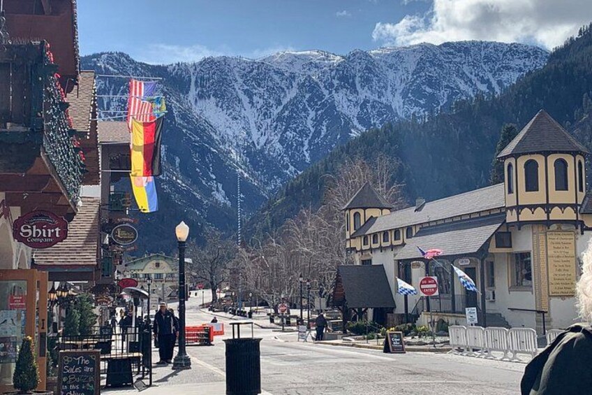 A street with buildings, a mountain in the background, and a flag. 1