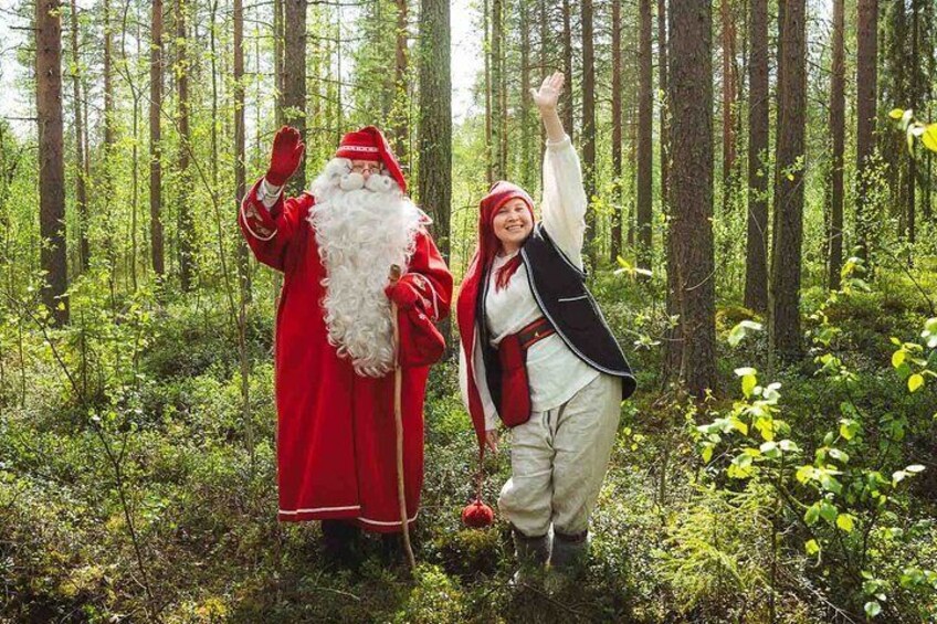 Two people in a forest, one dressed as Santa Claus and the other in traditional attire. 1