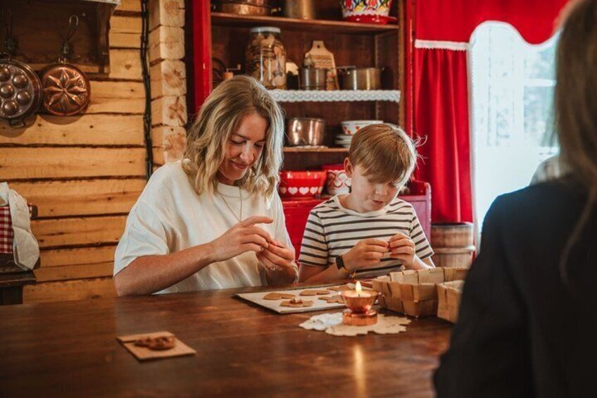 A wooden interior with a table, a child and an adult, and a red curtain. 3