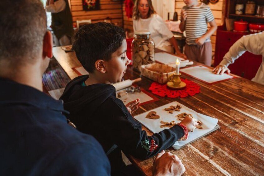 A wooden table with cookies, a candle, and a person in a striped shirt. 2