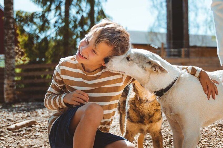 A person sitting on the ground with a dog. 1