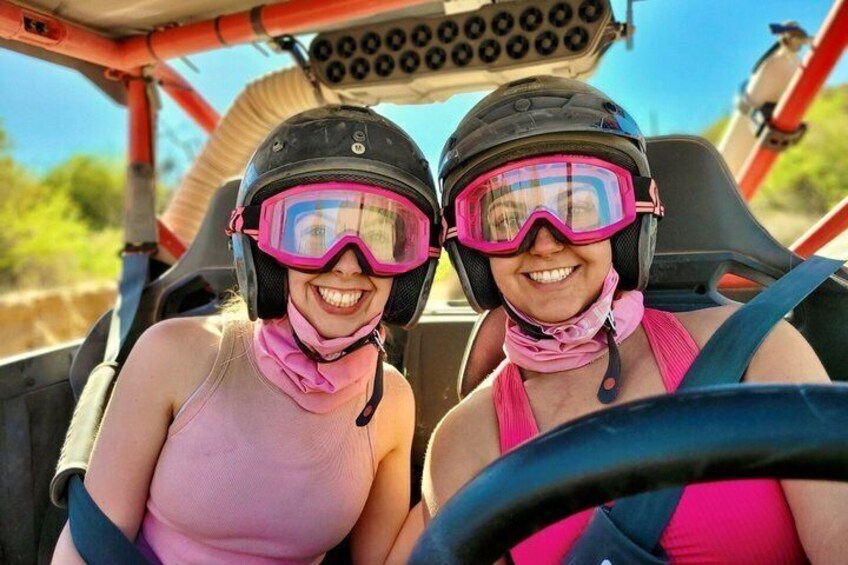 Two people in a vehicle with a steering wheel, wearing helmets and goggles. 5
