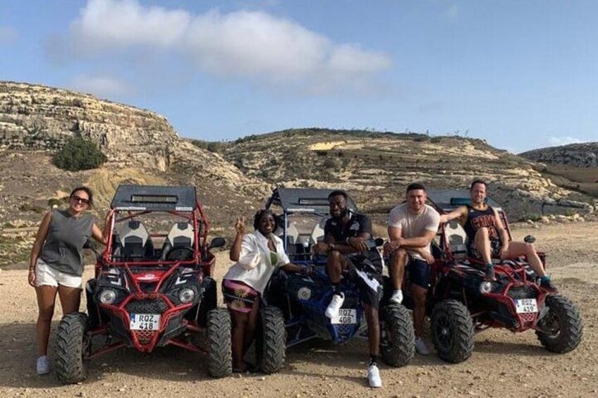 A group of people on ATVs in a rocky outdoor setting. 1