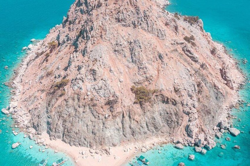 Una isla rocosa rodeada de aguas turquesas. 1