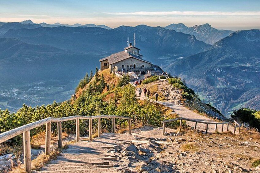 Una torre panoramica in montagna con una scala di legno che conduce verso l'alto, immersa in un paesaggio roccioso e con montagne sullo sfondo. 1