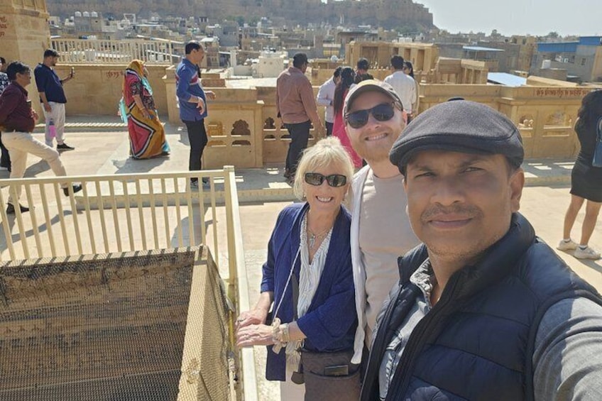 Eine Gruppe von Menschen auf einem Dach mit Blick auf eine Stadtlandschaft. 4