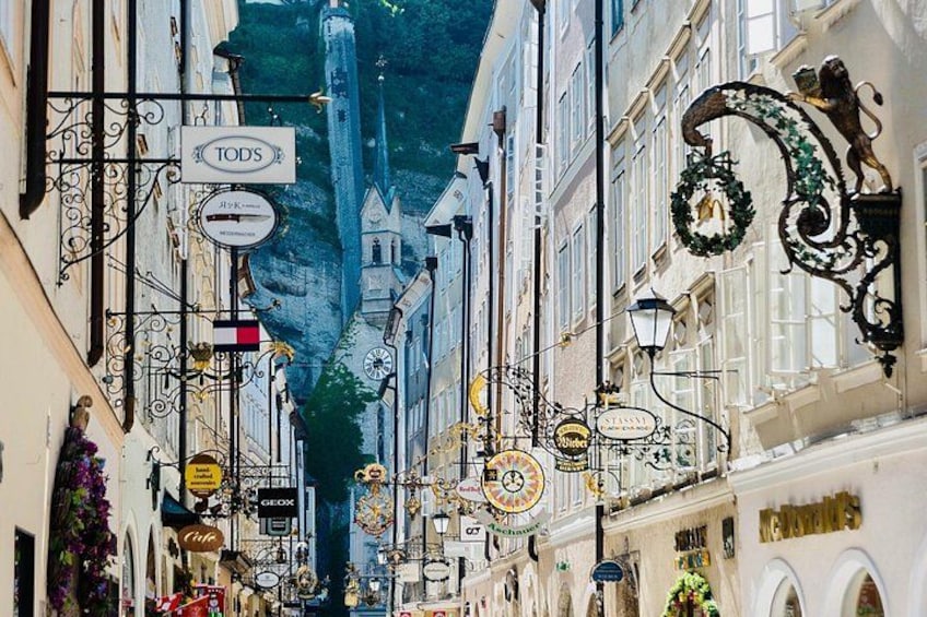 A street lined with buildings, some with ornate decorations and signs. 2