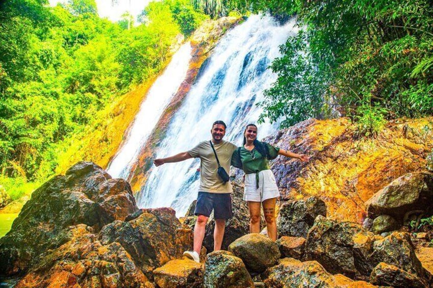 A waterfall with people standing on rocks. 3