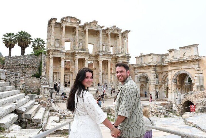 Una pareja de pie frente a unas ruinas antiguas con columnas y arcos. 1