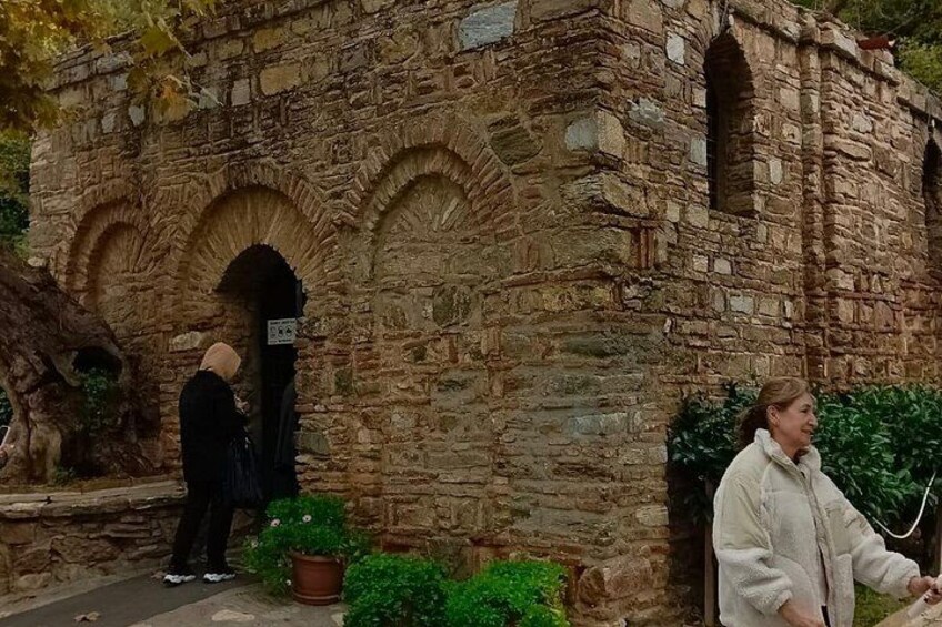 Un edificio de piedra con arcos, una planta en maceta y un cartel. 3