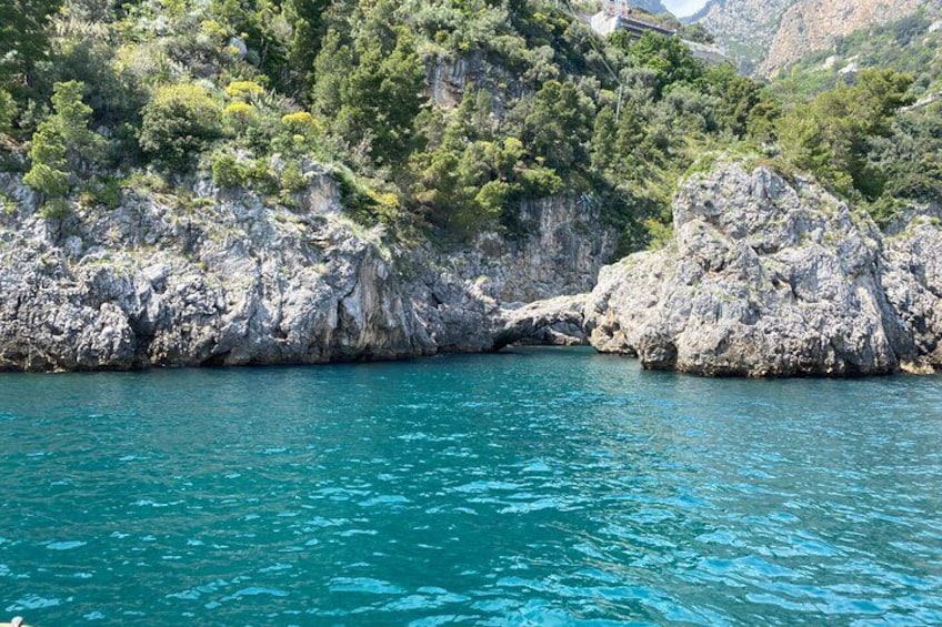 Paesaggio costiero con scogliere rocciose e acqua turchese cristallina. 1