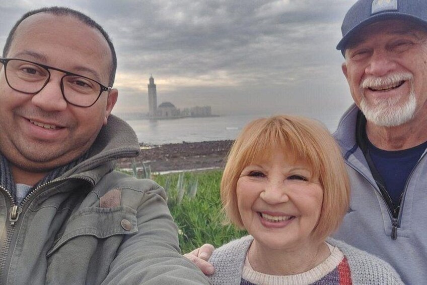 Tres personas frente a un cuerpo de agua, con un horizonte urbano de fondo. 4