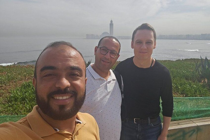 Three people standing in front of a body of water with a tall tower in the background. 5