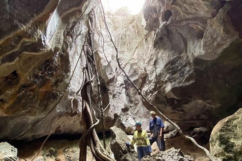 Dos personas explorando una cueva con estalactitas y estalagmitas. 3