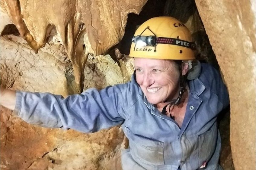 Una persona en una cueva, usando casco y una camisa azul. 2