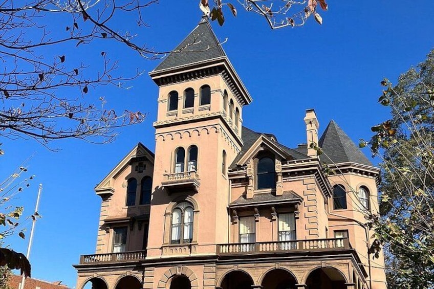 A large, historic building with a prominent tower and arched windows. 2