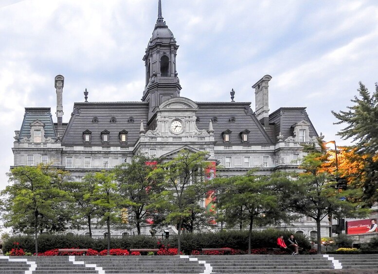 A large, historic building with a clock tower and a statue on top. 2