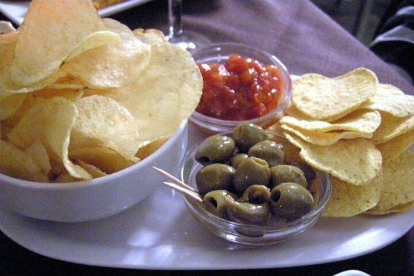 En tallrik med chips, salsa och oliver. 4