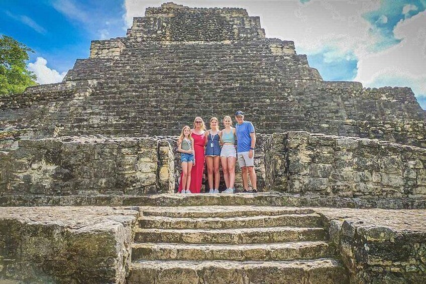 Un grupo de personas frente a antiguas ruinas de piedra con plataformas escalonadas. 3