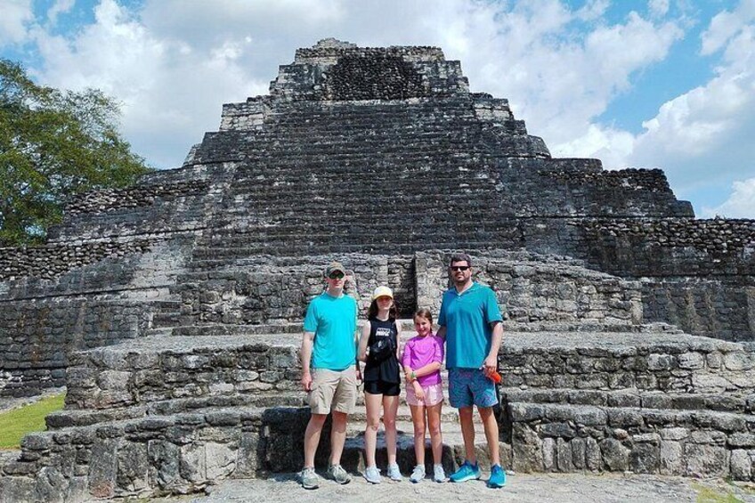 Un grupo de personas frente a una pirámide de piedra antigua y enorme. 4