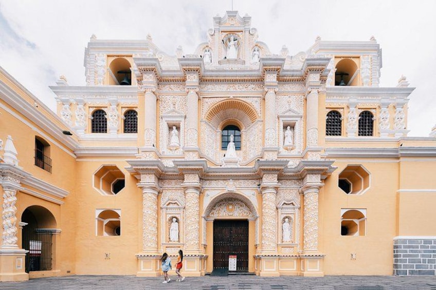 A colonial-style building with ornate architecture, including multiple arches and statues. 2