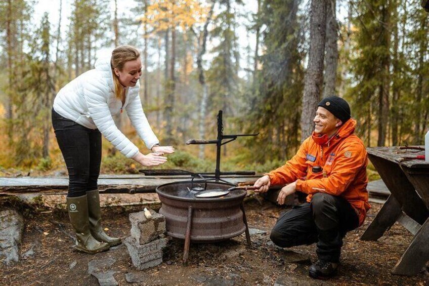 Two people near a campfire in a forest. 5