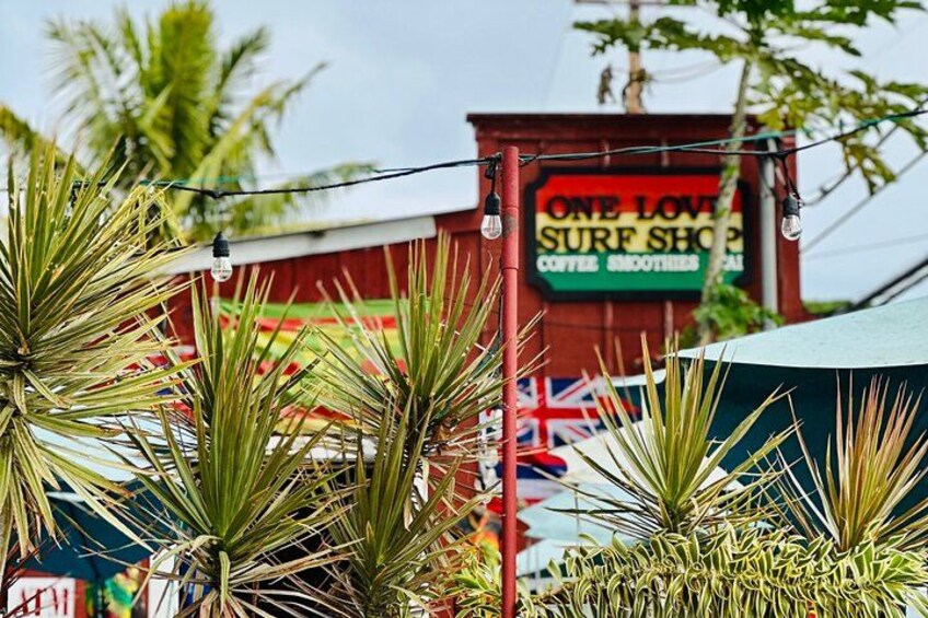 A red building with a sign that reads "ONE LOVE SURF SHOP COFFEE BRONTEA." 2
