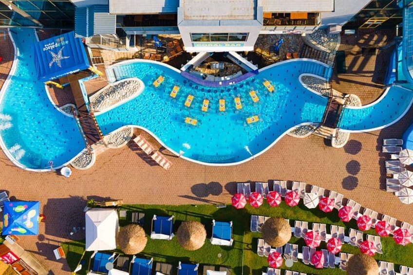 A cruise ship deck with a large swimming pool, sun loungers, and a lifeguard stand. 2